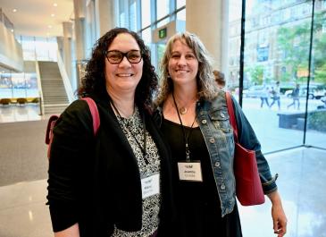 Two attendees smiling at the camera after registration