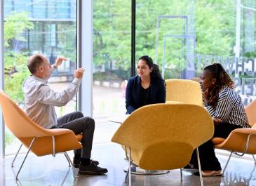 Attendees having a discussion in the foyer during a break