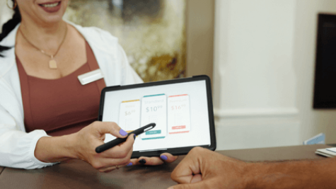 a woman presenting pricing options to a customer using their tablet