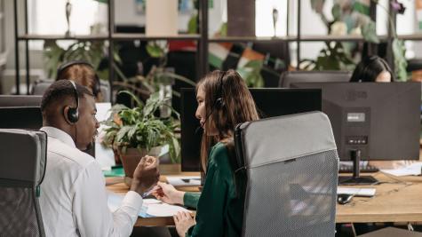 Two people sitting in office chairs having a conversation