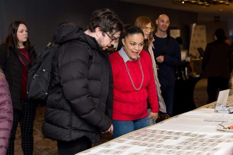 Guests standing at a table searching for their name tags