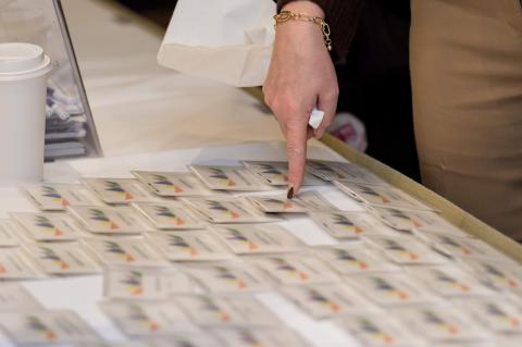 Someone pointing to a name tag on a table.
