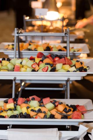 A multi-teared fruit tray on a buffet table.