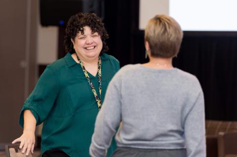 Two people talking and smiling at each other.