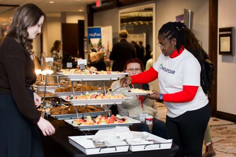 Conference attendees serving themselves at the catered food tables.