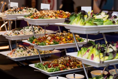 Three-tiered platters of food. Salad, vegetables, and other sauces accompany the plates.