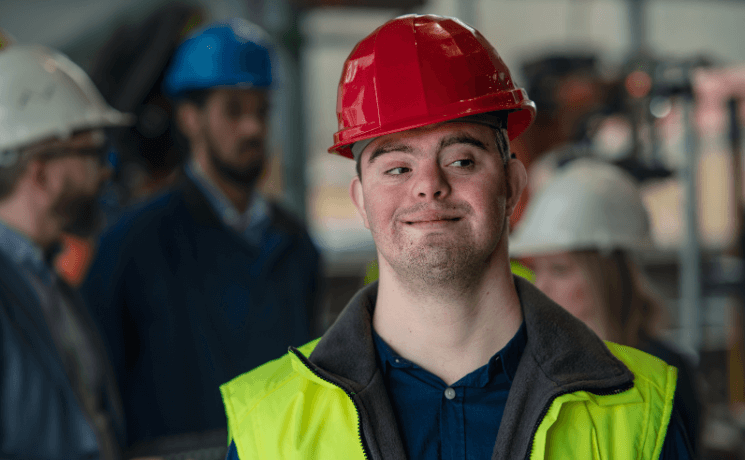 person with Down syndrom in a hard hat and safety vest