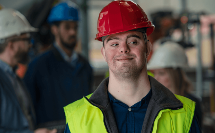 youth with Down syndrom wearing a hard hat an safety vest