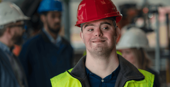 person with Down syndrom in a hard hat and safety vest