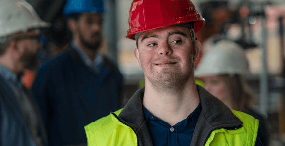 youth with Down syndrom wearing a hard hat an safety vest
