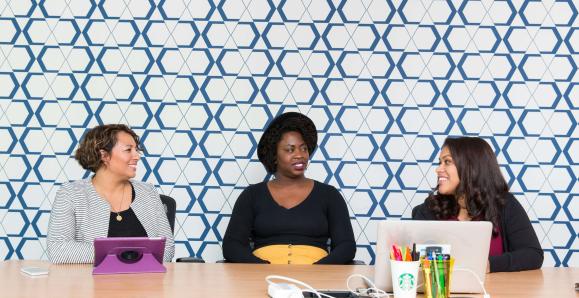 three women sitting together behind a table
