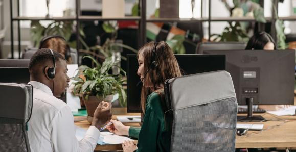 Two people sitting in office chairs having a conversation