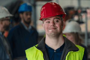 person with Down syndrom in a hard hat and safety vest