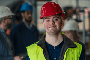 youth with Down syndrom wearing a hard hat an safety vest