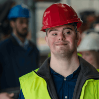 youth with Down syndrom wearing a hard hat an safety vest