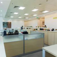 An office with cubicles sitting under florescent lights.