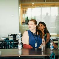 Three people at a table looking toward a presentation off screen